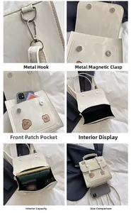 Detail view of cream white marble PU bag with bear embroidery and hardware features