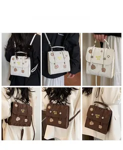 Detail showing embroidered cartoon patterns and texture on cream and brown vintage backpacks