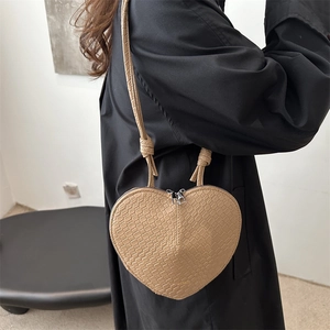 Sac à bandoulière cœur kaki minimaliste avec texture crocodile porté par un modèle