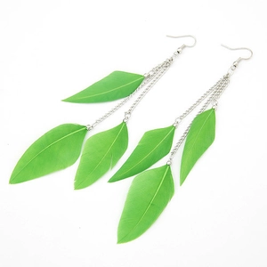 Close-up of bohemian style long green feather earrings with elegant silver chains