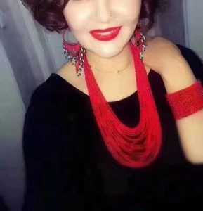 Detail of bohemian red seed bead jewelry set featuring multilayer tassel earrings and necklace
