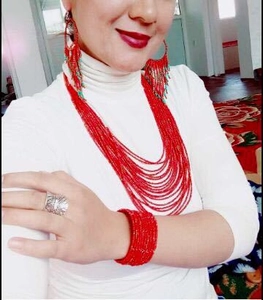 Detail of red seed bead jewelry set featuring multi-layer fringe necklace and earrings