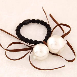 Détail d'élastique à cheveux avec perles blanches et rubans de soie marron foncé