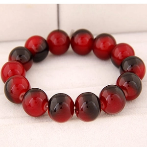 Detailed close-up of smooth round beads with red and black gradient on a bead bracelet
