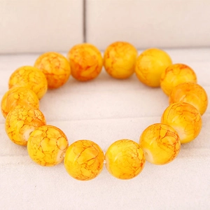 Detailed close-up of amber-like glass bead bracelet with marble texture on white background