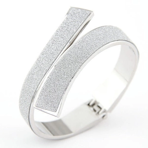 Primer plano del brazalete abierto plateado con acabado escarchado brillante y bordes pulidos