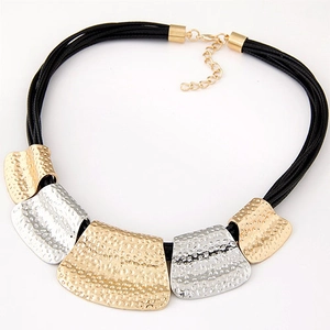 Close-up of bohemian layered cord necklace with gold and silver hammered metal charms