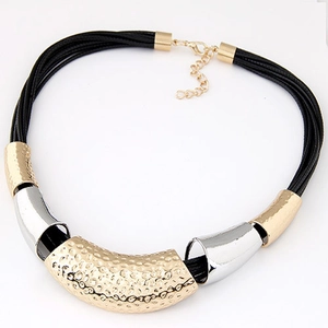 Detail of woven rope necklace featuring hammered gold and polished silver metal tubes