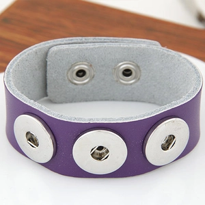 Detail eines lila Lederarmbands im Punk-Stil mit silbernen Druckknöpfen und verstellbarem Verschluss