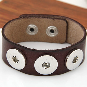 Makroaufnahme von dunkelbraunem breitem Lederarmband mit silbernen Nieten und Druckknöpfen