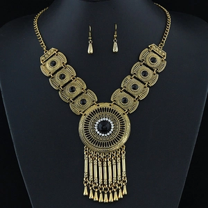 Vintage gold necklace set with black gemstone and fringe pendant on display