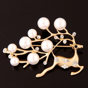 Élégante broche de renne dorée avec perles blanches et cristaux sur fond noir profond