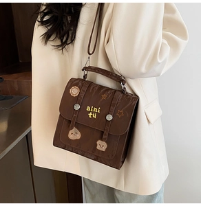 Detail of vintage brown nylon bag with cute embroidery patches and top handle