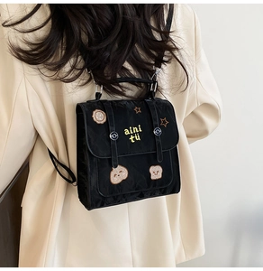 Detail of a black nylon mini backpack featuring sunflower and star cartoon embroidery