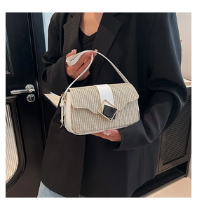 Vue détaillée du sac en paille tressée avec bordure en cuir blanc et boucle dorée
