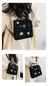 Close-up of black backpack featuring yellow 'aini tu' embroidery and cute star patterns