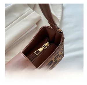Détail du zip doré lisse et des coutures sur un sac à main à imprimé léopard chic
