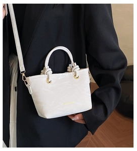 Macro shot of white leather bucket bag texture with gold metal eyelets and knot details