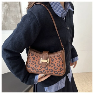 Détail du sac léopard avec bandoulière en cuir marron et boucle métallique élégante