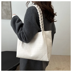 Gros plan du sac cabas blanc avec motif pied-de-poule gaufré et bandoulière tressée