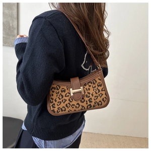 Gros plan d'un sac sous le bras imprimé léopard porté avec garniture en cuir brun