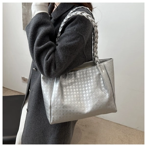 Dettaglio borsa shopper argento con trama pied de poule e tracolla intrecciata