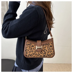 Détail de la texture léopard en daim et du fermoir doré sur le sac à bandoulière
