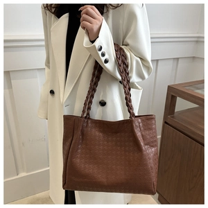 Détail d'un grand sac cabas marron avec texture gaufrée et anses en corde tressée
