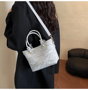 Detail of cream crossbody bucket bag with crinkled texture and gold Fashion logo