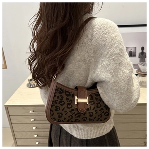 Détail du sac léopard vintage avec boucle en H dorée et finitions en cuir marron foncé