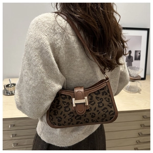 Détail du sac à bandoulière léopard avec bordure en cuir marron et fermoir métallique