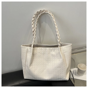 Dettaglio della borsa tote bianco sporco con motivo a rilievo e manici intrecciati