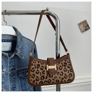 Gros plan du sac sous l'aisselle à motif léopard avec bordure cuir et boucle H dorée
