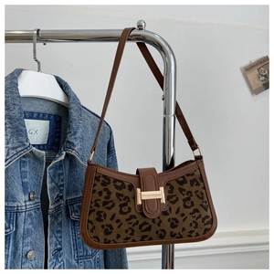 Détail d'un sac à main léopard avec boucle dorée en H et bandoulière en cuir marron