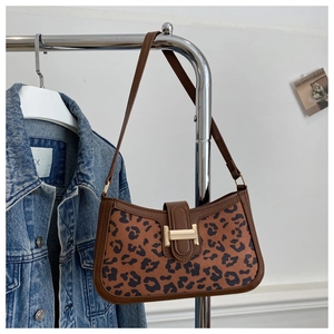 Détail du sac léopard vintage avec garniture en cuir marron et boucle dorée élégante