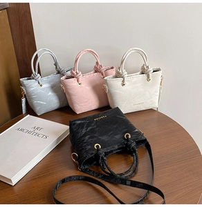 Detail of four bucket bags in various colors with pleated texture and adjustable straps