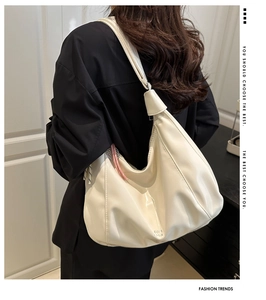 Dettaglio della tracolla con nodo e trama in pelle liscia sulla grande borsa hobo crema