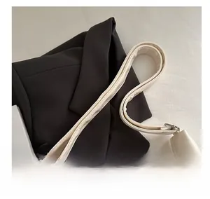 Detail of wide cream leather shoulder strap with sturdy metal swivel hooks on a tote bag
