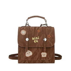 Brown vintage style backpack with embroidery detail and top handle on white background
