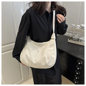 Macro shot of the glossy cream-colored hobo bag with unique knotted strap detail