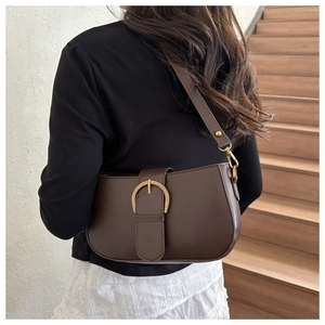 Détail du sac porté épaule marron avec une grande boucle fer à cheval dorée