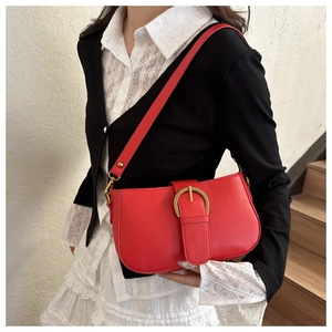 Détail du sac sous l'aisselle en cuir rouge avec boucle vintage et garniture dorée