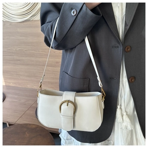 Détail d'un sac sous le bras en cuir blanc avec boucle en bronze vintage et sangle décorative