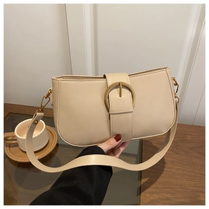 Détail du sac beige avec boucle fer à cheval dorée et texture cuir raffinée