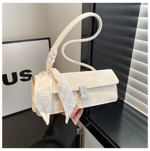Détail du sac baguette blanc avec boucle en strass et foulard en soie à imprimé cœurs