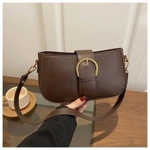 Vue détaillée d'un sac à bandoulière marron mat avec une boucle dorée vintage