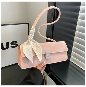 Détail du sac baguette rose avec boucle en cristal et foulard en soie sur l'anse