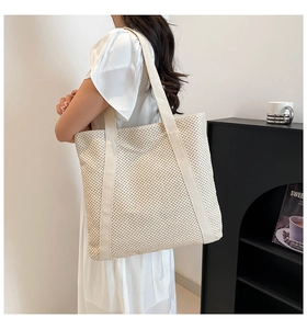 Grand sac cabas tressé beige porté à l'épaule pour le quotidien ou la plage
