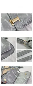 Detail of grey marble texture baguette bag with gold metal buckle and reinforced stitching