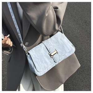 Light blue baguette bag with pleated texture and gold H buckle shown on model